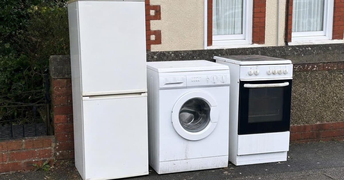 Old white goods including a fridge and washing machine ready for disposal in Eastbourne